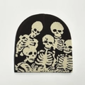 Detailansicht der schwarzen Strickmütze mit weißen Totenkopfmustern für Halloween - Einheitsgröße / Kaffeebraun