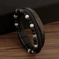 Dettaglio di bracciale in pelle multistrato con perle nere opache e texture marmoree - Pietra Paesaggio