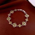 Detail of silver clover bracelet featuring olive green zircon stones on silk fabric - Silver Base-Green