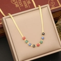 Detailed shot of golden snake chain necklace with colorful evil eye charms in a box - Necklace
