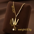 Golden titanium steel necklace with W-letter pendant and cube tassel on velvet stand - Letter W / Gold
