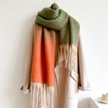 Detail eines grün-orangen Farbverlaufschals mit beigen Fransen auf einem Wollmantel - Orange Grün