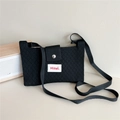 Close-up of black knitted crossbody bag with diamond texture and magnetic buckle - Black