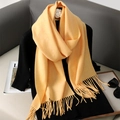 Elegant mustard yellow faux cashmere scarf with tassels styled over a black outfit - Bright Yellow