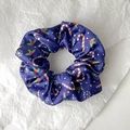 Gros plan d'un chouchou en satin bleu foncé avec des motifs de cannes de Noël et houx - Style 10 (Bleu Foncé Éléments de Noël)