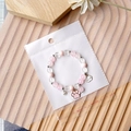 Pink and white beaded bracelet with cat paw charm in transparent self-adhesive bag - Yin Yang Packaging Bag