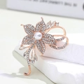 Close-up of rose gold flower brooch with white pearl and sparkling crystal detail - Rose Gold Flower