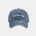 Dettaglio del ricamo bad hair day su un berretto da baseball in denim blu lavato - Regolabile / Blu navy