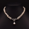 Freshwater pearl necklace with a rhinestone bow pendant and teardrop pearl on black neck model - Natural Pearl Bowknot Style