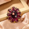 Elegant gold flower brooch with deep purple crystals and iridescent rhinestone accents - Purple