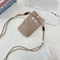 Pochette de téléphone en tissu à carreaux marron et blanc avec cordon sur un bureau épuré - Carreaux Marron