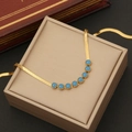 Collana a catena a serpente dorata con ciondoli occhio blu in portagioie beige - Collana