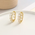 Detailed close-up of gold hoop earrings with square zircons on white ceramic plate - White (ZYN-DME454G-4)