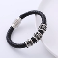 Men's black braided leather bracelet with silver skull magnetic clasp on a white plate - Black Skull