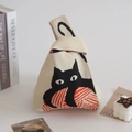 Chic knit knot bag in cream white featuring a playful black cat and red yarn ball pattern - Yarn Ball Cat