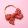 Detail of orange muslin cotton bow headband with elastic beige nylon band for babies - Pumpkin Orange