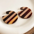 Detailed view of C-shaped earrings made from layered wood and amber resin textures - Brown