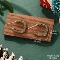 Détail de boucles d'oreilles dorées en C avec strass foncés au décor de Noël - Forme en C Dorée Avec Strass Gris Fumé