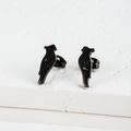 Macro detail of bird shaped matte black stainless steel earrings on white stone - Bird / Black