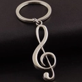 Polished silver metal treble clef keychain with music note pendant on leather background - Treble Clef Style / Silver