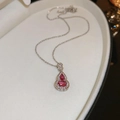 Macro view of a red cat eye stone gourd pendant with sparkling pavé crystal accents - Purple Zircon Gourd Necklace / Purple/Silver