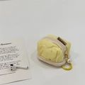 Detail of yellow quilted heart-stitched pouch for AirPods with pearl charm and hook - Yellow