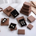 Textured brown jewelry gift boxes in various sizes on white marble and silk - Coffee Brown