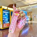 Macro detail of a cute pink unicorn liquid keychain with silicone strap and bell charm - Luminous Donut Milk Tea Cup