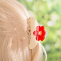 Pince à cheveux beige à fleurs rouges portée sur des cheveux blonds - Pince à Cheveux Fleur Rouge