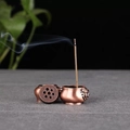 Vista macro de un quemador de incienso de cobre vintage con tapa y humo suave - Oreja de León Pequeña