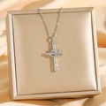Collana a croce in argento con cuori intrecciati e zirconi su sfondo di seta elegante - Argento Croce