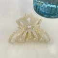 Close-up of beige marble acetate hair claw clip with rhinestones and gold text - Custard Yellow Agate - Rhinestone