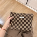 Detailed texture of brown checkered corduroy bag with a white fabric label - Light Brown Checkerboard