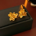 Nahaufnahme goldener Lotusblüten-Ohrstecker auf einer schwarzen Schmuckschachtel - 925 Silberstift Lotus Goldene Ohrstecker / Gold