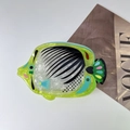 Macro detail of a tropical fish hair claw made from lime green acetate with colorful patterns - Pouting Fish