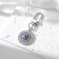 Close-up of silver evil eye keychain with sparkling rhinestones on stone background - Silver Round Hollow Rhinestone Evil Eye