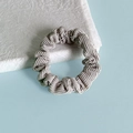 Détail d'un chouchou en velours côtelé gris clair avec texture élastique plissée - Gris