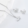 Detailed view of silver butterfly necklace and stud earrings set on white stone decor - Steel White