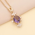 Macro shot of an oval purple gemstone pendant with white zircon halo on a gold chain - Purple