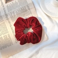 Elegant red velvet scrunchie shown on a vintage newspaper background for casual styling - Burgundy