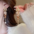 Close-up of elegant gold flower beaded tassel earrings worn by a model in soft lighting - Gold Flower Coffee Beaded Long (70#)