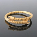 Macro detail of golden cable twisted cuff bracelet with ornate royal crown terminals - Crown Head Bangle Gold