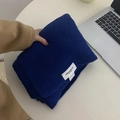 Thick navy blue ribbed knit scarf folded on a table with a laptop and neutral background - Dark Blue