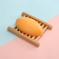Handmade orange oval soap on a natural wooden tray over a blue and pink background - 110g Thai-style Papaya Soap