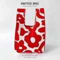 Detail of red and white floral knit tote bag showing thick texture and woven flower patterns - Red Mixed Flowers