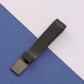 Vista dettagliata di un fermacravatta in metallo nero opaco su uno sfondo blu e bianco sobrio - Fermacravatta a Specchio Nero