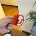 Detail showing an apple-shaped hair claw clip with red resin finish and golden accents - Apple