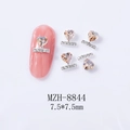 Close-up of heart-shaped nail charm with silver base and rhinestone inlay on a pink nail - Champagne Style (8844)