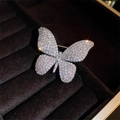 Elegant butterfly brooch with sparkling rhinestones set on a dark velvet display box - Silver