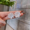 Macro shot of white floral earrings with layered petals being held to show size - A1421 White Floral Stud Earrings